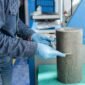 manos de trabajadores industriales masculinos con guantes de latex azul midiendo un cilindro de hormigon 85x85